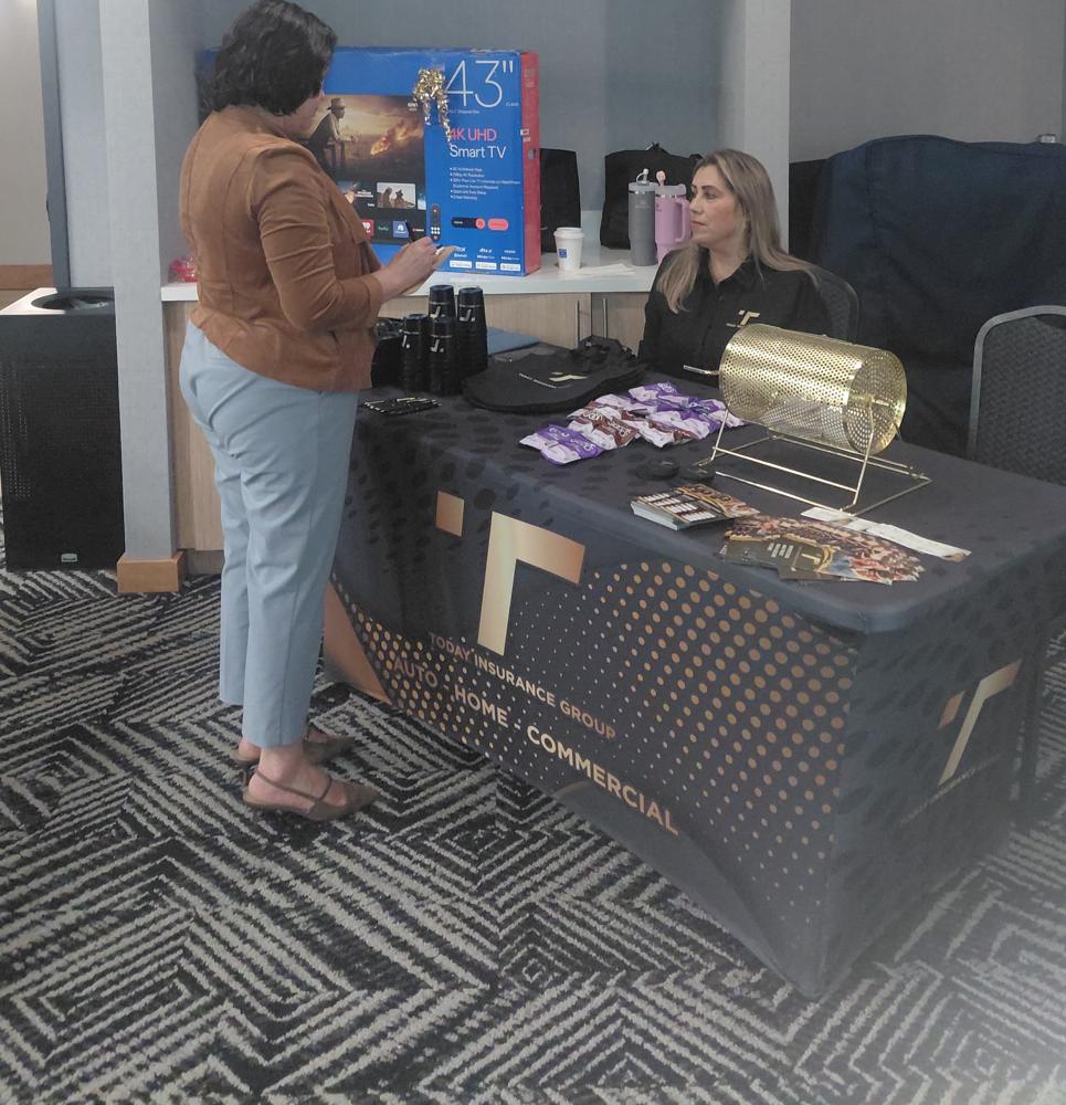 Atendiendo a una visitante en el stand